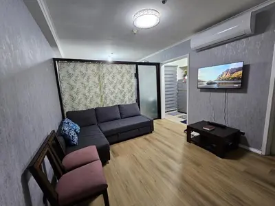 a living room with a couch and a tv at South of Market Private Residence in Manila