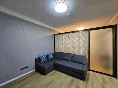 a living room with a couch and a window at South of Market Private Residence in Manila