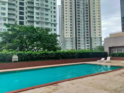 a swimming pool in a city with tall buildings at South of Market Private Residence in Manila