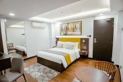 a hotel room with a large bed and a chair at ASN Boutique Residence in Manila