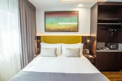 a bedroom with a large white bed with a yellow headboard at ASN Boutique Residence in Manila