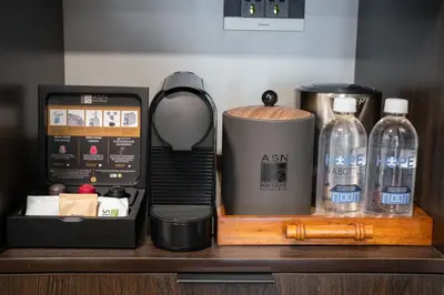 a counter with a coffee maker and bottles of water at ASN Boutique Residence in Manila