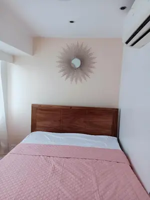 a bedroom with a bed and a mirror on the wall at Fort Victoria Condominium Tower C in Manila