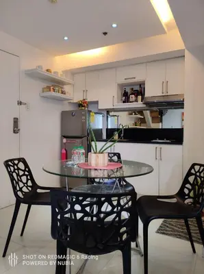 a kitchen with a table and chairs in a room at Fort Victoria Condominium Tower C in Manila