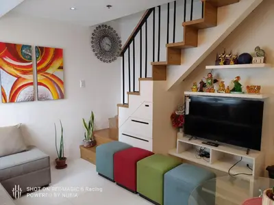 a living room with a tv and a colorful stool at Fort Victoria Condominium Tower C in Manila