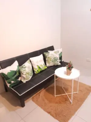 a black couch with pillows and a table in a room at Jam Staycation at Shell Residences in Manila