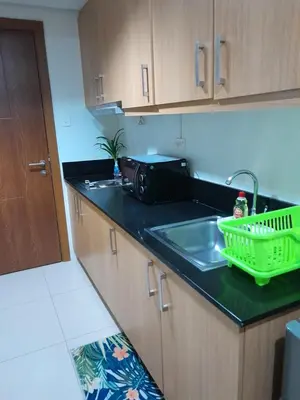 a kitchen counter with a sink and a microwave at Jam Staycation at Shell Residences in Manila