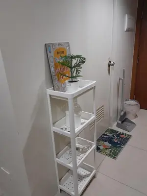a white shelf with a plant on it in a bathroom at Jam Staycation at Shell Residences in Manila