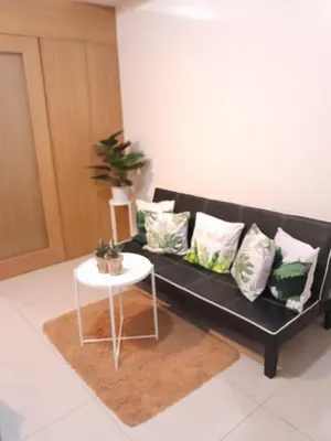 a black couch with pillows and a table in a room at Jam Staycation at Shell Residences in Manila