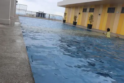a child standing in a pool of water in a building at CONDOMINIUM AT TAFT AVENUE, MALATE, Manila in Manila