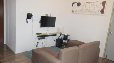 a living room with a couch and a desk with a television at CONDOMINIUM AT TAFT AVENUE, MALATE, Manila in Manila