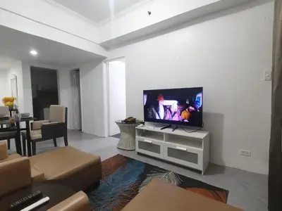 a living room with a flat screen tv on a white wall at Comfort Accommodation Services in Manila