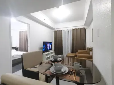 a living room with a table and a dining room at Comfort Accommodation Services in Manila