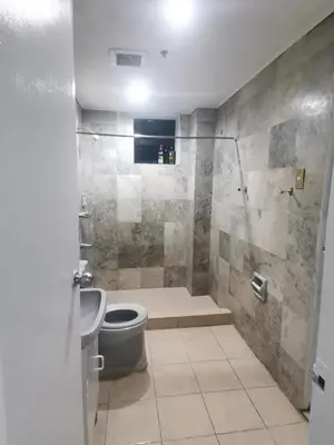 a bathroom with a shower and a toilet and a sink at Comfort Accommodation Services in Manila