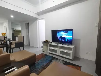 a living room with a flat screen tv on a white wall at Comfort Accommodation Services in Manila