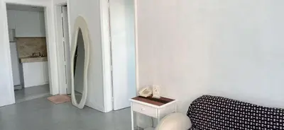 a white room with a bed and a phone on a table at Comfort room in Manila