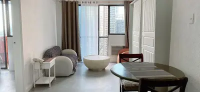 a living room with a table and a chair and a couch at Comfort room in Manila