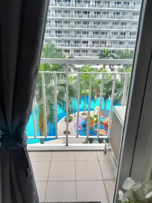 a view of a pool from a hotel room window at Jamaica's Place 1br Amenities View at Shell Residences in Manila