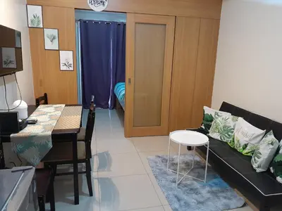 a living room with a couch and a table at Jamaica's Place 1br Amenities View at Shell Residences in Manila