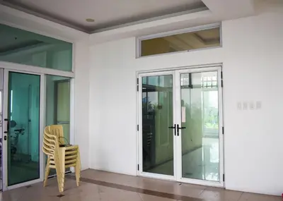 a room with glass doors and a yellow chair at The Boni Tower by RSPL Manila City Center in Manila
