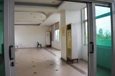 an empty hallway in an office building with a window at The Boni Tower by RSPL Manila City Center in Manila