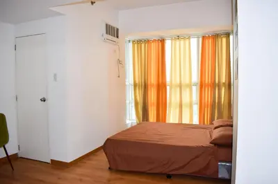 a small bedroom with a bed and a window at The Boni Tower by RSPL Manila City Center in Manila
