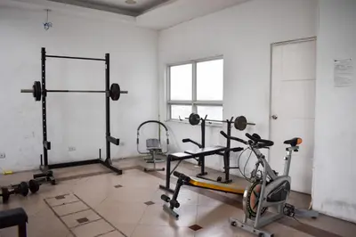 a gym with bikes and weights in a room at The Boni Tower by RSPL Manila City Center in Manila