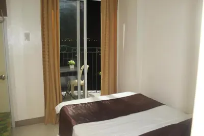a room with a bed and a window with a balcony at CHATEAU ELYSEE a7 near Airport and Sm mall in Manila