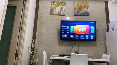 a television on a wall with a table and chairs at CHATEAU ELYSEE a7 near Airport and Sm mall in Manila