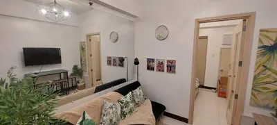 a living room with a couch and a tv at CHATEAU ELYSEE a7 near Airport and Sm mall in Manila