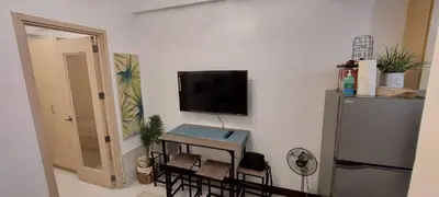 a room with a table and a television on a wall at CHATEAU ELYSEE a8 near Airport and Sm mall, WIFI in Manila