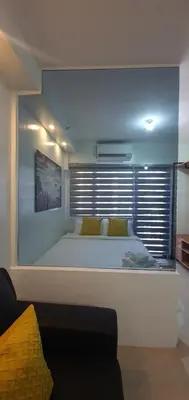 a bedroom with a large white bed with a window at Shore 2 residences condominium in Manila