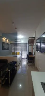 a bedroom with a bed and a desk and a table at Shore 2 residences condominium in Manila