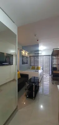 a bedroom with a bed and a couch in a room at Shore 2 residences condominium in Manila