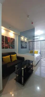 a living room with a bed and a couch at Shore 2 residences condominium in Manila