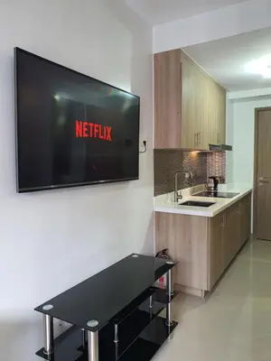 a television hanging on a wall in a kitchen at Shore 2 residences condominium in Manila