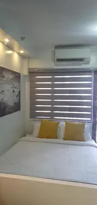 a large bed in a room with a window at Shore 2 residences condominium in Manila