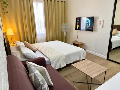 a hotel room with a bed and a couch at Hannah’s Morning Sun - Studio Room in Manila