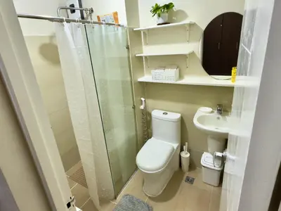 a bathroom with a shower and a toilet and a sink at Hannah’s Morning Sun - Studio Room in Manila