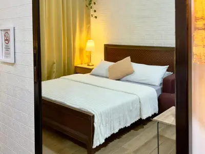 a bedroom with a bed with white sheets and pillows at Hannah’s Morning Sun - Studio Room in Manila