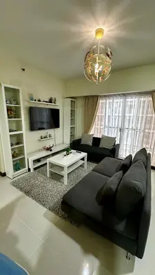 a living room with a black couch and a tv at TresMariasCrib 3BR Unit at Pasig City Philippines in Manila