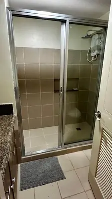 a shower with a glass door in a bathroom at TresMariasCrib 3BR Unit at Pasig City Philippines in Manila