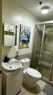a bathroom with a toilet and a sink and a shower at TresMariasCrib 3BR Unit at Pasig City Philippines in Manila