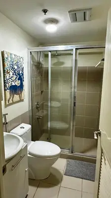 a bathroom with a shower and a toilet and a sink at TresMariasCrib 3BR Unit at Pasig City Philippines in Manila