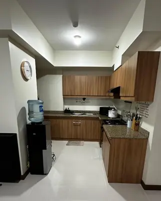 a kitchen with wooden cabinets and a counter top at TresMariasCrib 3BR Unit at Pasig City Philippines in Manila