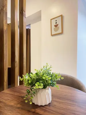 a vase with a plant on a wooden table at Airo Suites Makati in Manila