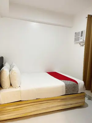 a bedroom with a bed with white sheets and pillows at Airo Suites Makati in Manila