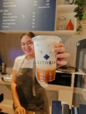 a woman is holding a cup of beer at Airo Suites Makati in Manila