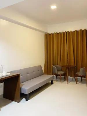 a living room with a couch and some chairs at Airo Suites Makati in Manila
