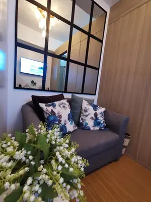 a living room with a couch and a large window at Nathan's Pad @ Grace residences Nr. BGC in Manila